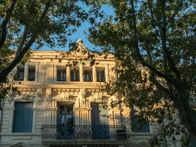 a white building with trees in front of it at Le Loft De La Robine 110m2 in Narbonne
