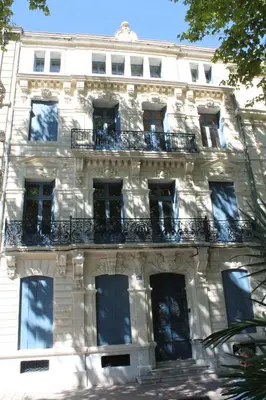 a white building with windows and a balcony at Le Loft De La Robine 110m2 in Narbonne