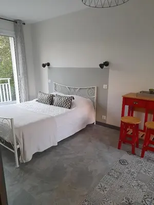 a bedroom with a bed and a table and a window at Chabas Studio in Lagarrigue