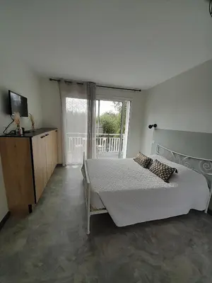 a bedroom with a bed and a large window at Chabas Studio in Lagarrigue