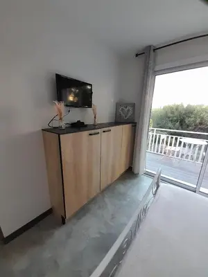 a living room with a tv and a large window at Chabas Studio in Lagarrigue