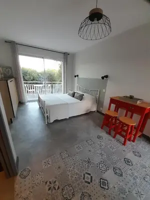 a bedroom with a bed and a table and a window at Chabas Studio in Lagarrigue