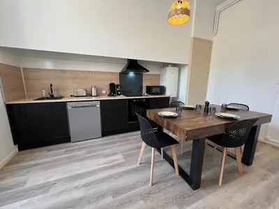 a kitchen with a table and chairs in a room at L'Excellence, Joli T3 Bourgeois in Carcassonne