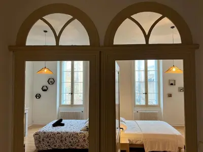 a bedroom with two beds and two windows at L'Excellence, Joli T3 Bourgeois in Carcassonne