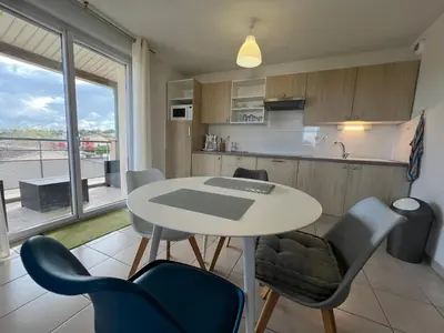 a kitchen with a table and chairs and a kitchen with a window at Le Parc! T3 climatisé, Parking, Piscine in Carcassonne