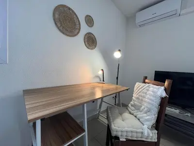 a room with a wooden table and a chair at Le Parc! T3 climatisé, Parking, Piscine in Carcassonne