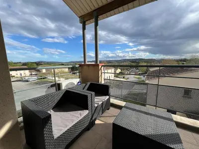 a balcony with furniture and a view of a city at Le Parc! T3 climatisé, Parking, Piscine in Carcassonne