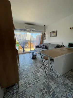 a living room with a table and a couch at Joli Appt Port la Nouvelle in Port-la-Nouvelle
