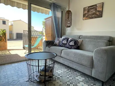 a living room with a couch and a table at Joli Appt Port la Nouvelle in Port-la-Nouvelle
