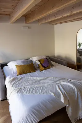 a large white bed in a room with wooden ceilings at La Parenthèse Naillousaine in Nailloux