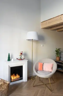 a living room with a chair and a fireplace at La Parenthèse Naillousaine in Nailloux