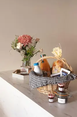 a basket of food and flowers on a table at La Parenthèse Naillousaine in Nailloux