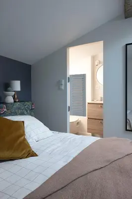 a bedroom with a white bed and a mirror at La Parenthèse Naillousaine in Nailloux