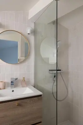 a bathroom with a shower with a sink and a mirror at La Parenthèse Naillousaine in Nailloux