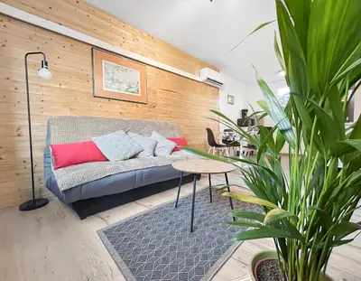 a living room with a couch and a table at Terrasse, parking & confort au cœur de Carcassonne in Carcassonne