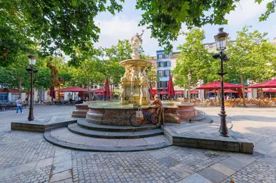 a fountain in the middle of a city street at Terrasse, parking & confort au cœur de Carcassonne in Carcassonne