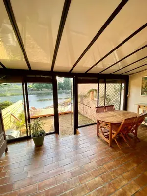 a large room with a wooden table and glass doors at Gîte Massibel au coeur de Brassac in Brassac