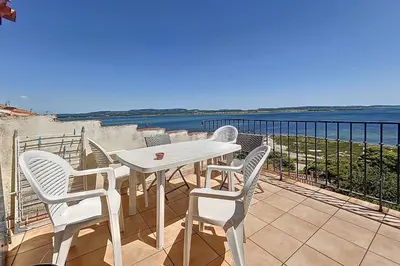 a white table and chairs on a balcony with the ocean at Charming house with terrace and breathtaking views in Bages
