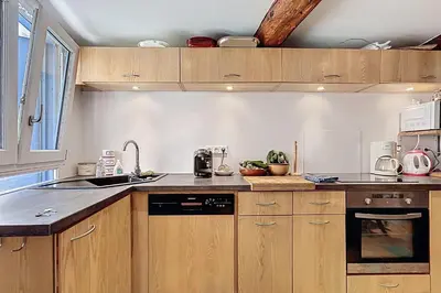 a kitchen with wooden cabinets and a sink at Charming house with terrace and breathtaking views in Bages