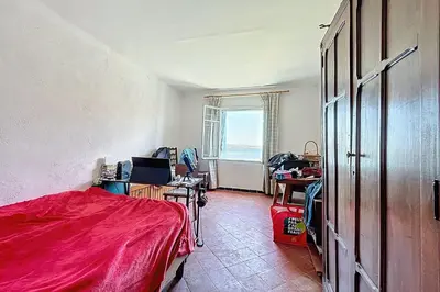 a room with a bed and desks and a window at Charming house with terrace and breathtaking views in Bages