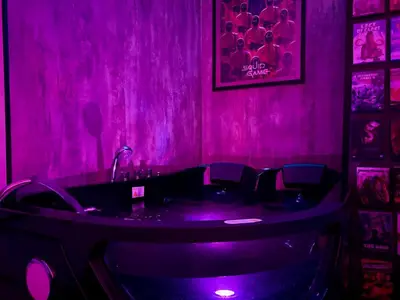 a purple room with a bath tub in it at LOVE IN CINÉ Appartement cinéma balnéo in Pamiers