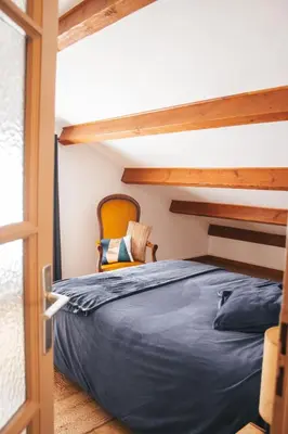 a bedroom with a bunk bed with a chair next to a window at L'Eau Vive Villa 6 pers parc 3000m2 à 50 m de la rivière in Fraisse-sur-Agout