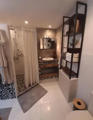 a bathroom with a shower curtain and a sink at Chez Pet and Jo in Olargues