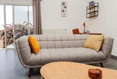 a living room with a couch and a table at L'Escapade Jaune - Jacuzzi, Wi-Fi, tout équipée in Carcassonne