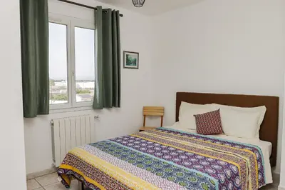 a bedroom with a bed and a window at L'Escapade Jaune - Jacuzzi, Wi-Fi, tout équipée in Carcassonne