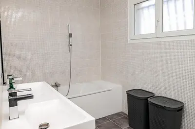 a bathroom with a sink and a tub and a toilet at L'Escapade Jaune - Jacuzzi, Wi-Fi, tout équipée in Carcassonne