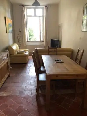 a living room with a table and a couch at Tranquille et chaleureux in Carcassonne