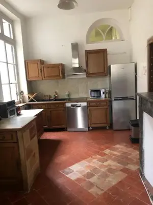 a kitchen with stainless steel appliances and wooden cabinets at Tranquille et chaleureux in Carcassonne