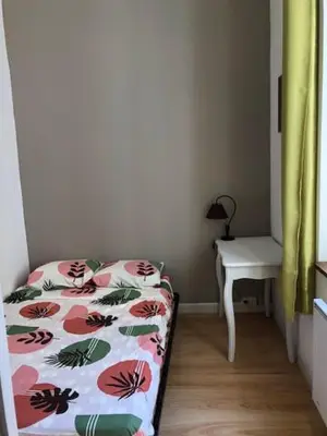 a bedroom with a bed and a desk and a table at Tranquille et chaleureux in Carcassonne