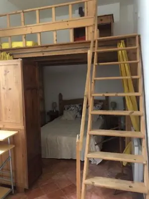 a wooden bunk bed with a ladder in a room at Tranquille et chaleureux in Carcassonne