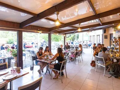 a group of people sitting at tables in a restaurant at Mobil-home confortable avec terrasse - API-1-52-652 in Lézignan-Corbières