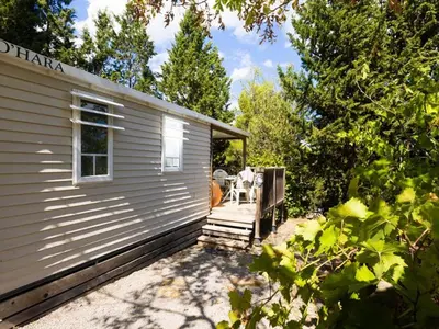 a small house with a porch and a patio at Mobil-home confortable avec terrasse - API-1-52-652 in Lézignan-Corbières