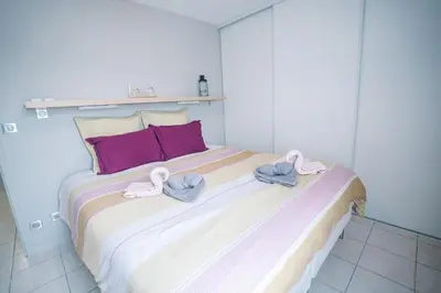 a bed with two towels on top of it at Parking Sécurisé -Climatisé-Piscine-Terrasse-AM in Carcassonne