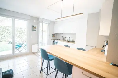 a kitchen with a wooden counter top and blue chairs at Parking Sécurisé -Climatisé-Piscine-Terrasse-AM in Carcassonne