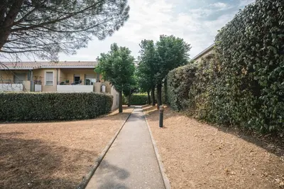 a sidewalk in front of a house with trees at Parking Sécurisé -Climatisé-Piscine-Terrasse-AM in Carcassonne
