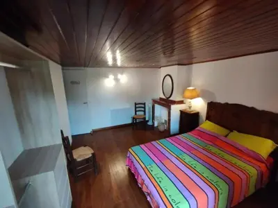 a bedroom with a colorful bed and a wooden ceiling at Gite de l'abreuvoir in Saint-Gaudéric