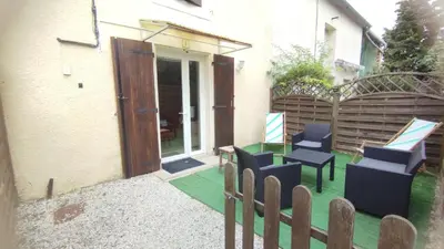 a patio with chairs and a door to a house at Gite de l'abreuvoir in Saint-Gaudéric