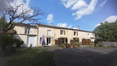 a large white house with plants in a yard at Gite de l'abreuvoir in Saint-Gaudéric
