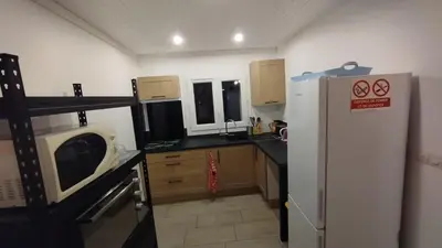 a small kitchen with a refrigerator and a microwave at Gite de l'abreuvoir in Saint-Gaudéric