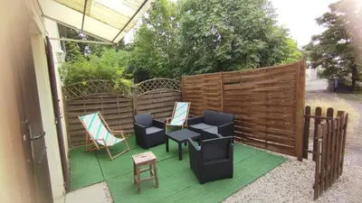 a patio with chairs and tables and a fence at Gite de l'abreuvoir in Saint-Gaudéric