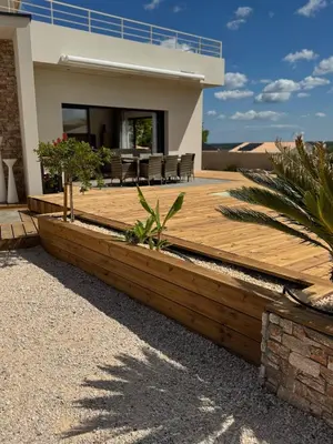 a wooden deck in front of a house at Modern villa with sea view in Fitou