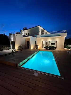 a villa with a swimming pool at night at Modern villa with sea view in Fitou