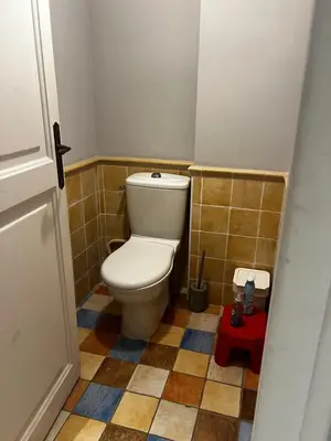 a small bathroom with a toilet and a red stool at Maison Gally Historic Luxury in Carcassonne