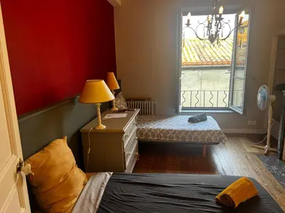 a bedroom with a bed and a dresser and a window at Maison Gally Historic Luxury in Carcassonne
