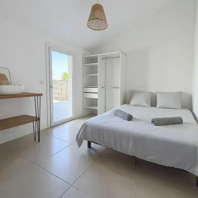a white bedroom with a large bed and a desk at Maison avec Jardin, Terrasse, cheminée insert et bois in Carcassonne