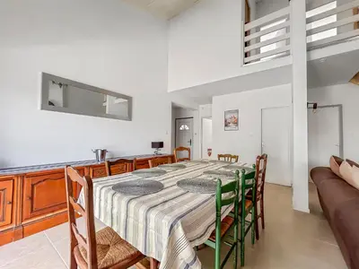 a kitchen and dining room with a table and chairs at Maison avec Jardin, Terrasse, cheminée insert et bois in Carcassonne